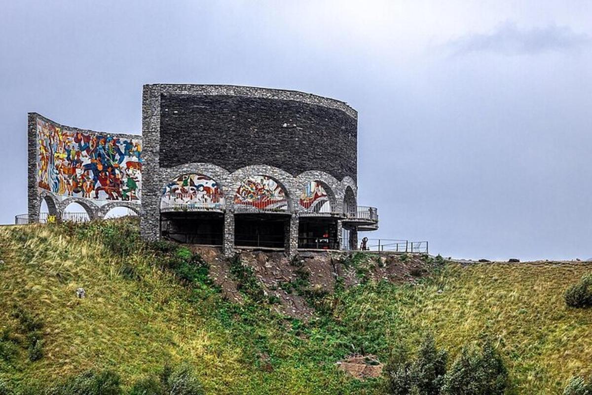 un edificio con un murale sul fianco di una collina