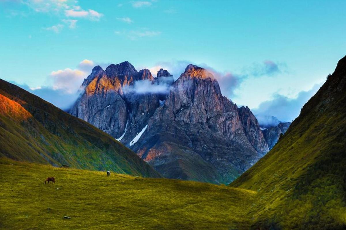 una vista d'una serralada amb un camp verd