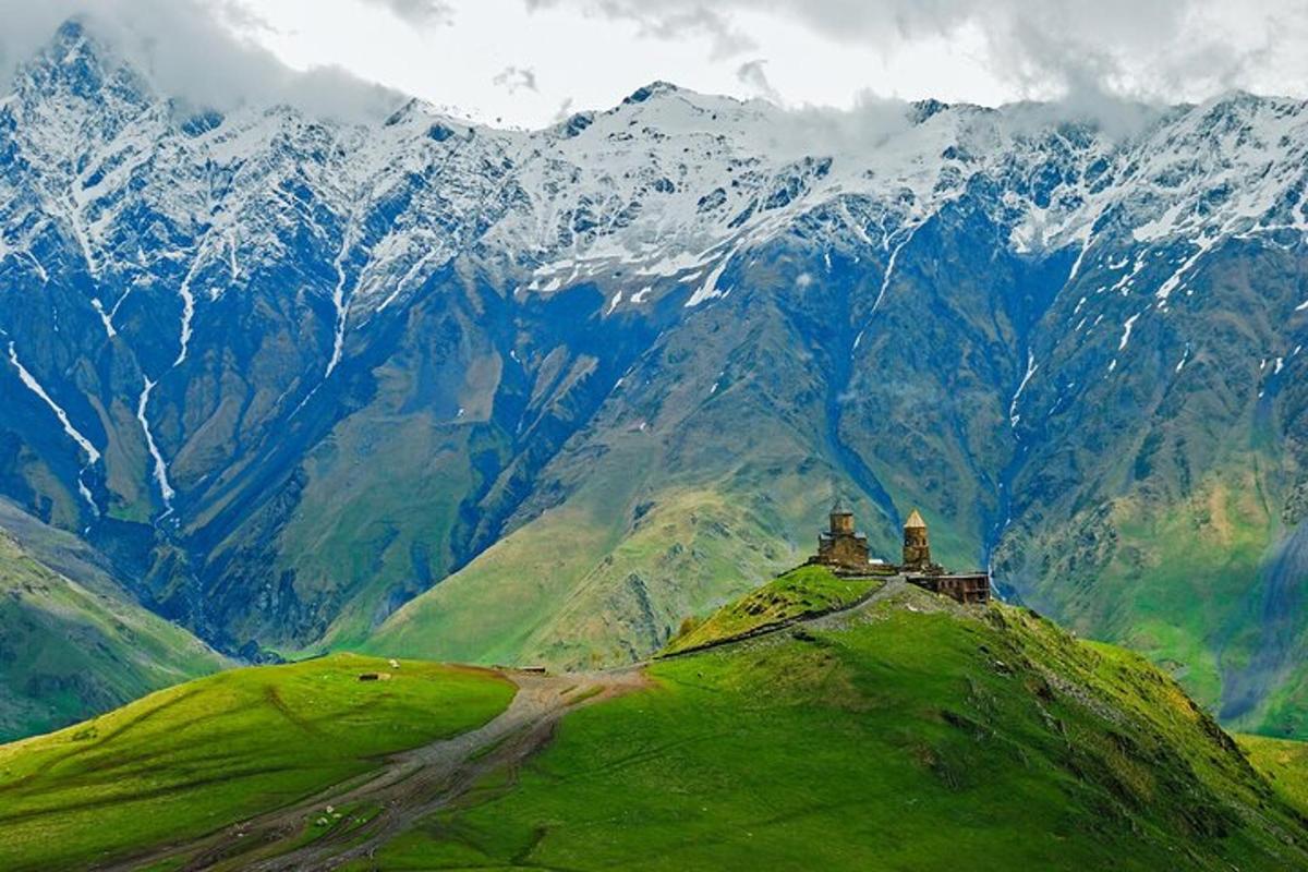 una casa in cima a una collina verde con montagne