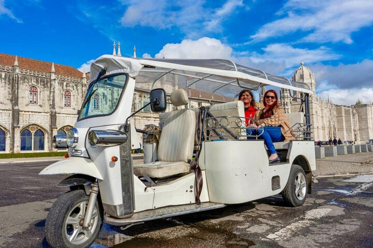 deux femmes sont assises dans une voiturette de golf