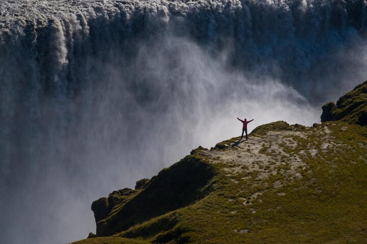 maður sem stendur á fjallstindi