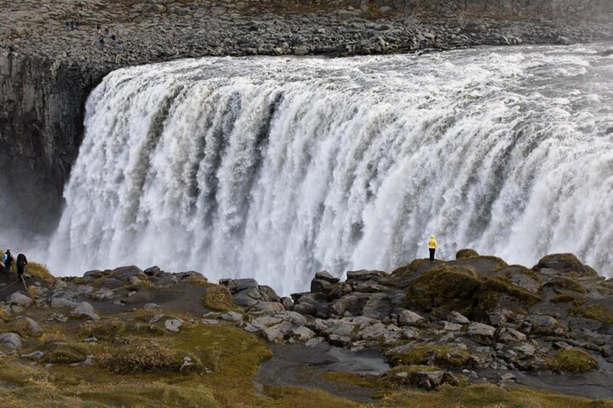 maður stendur fyrir framan foss