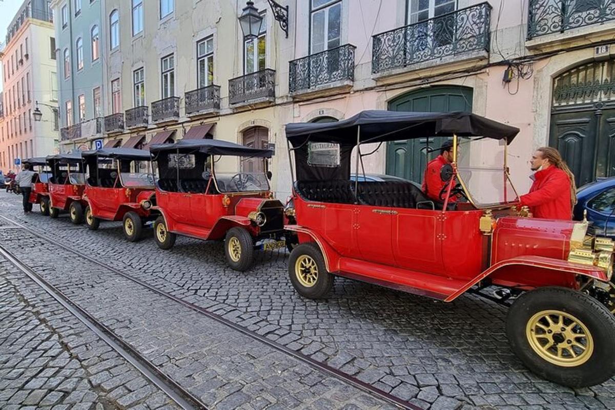 Una fila de viejos coches rojos circulando por una calle