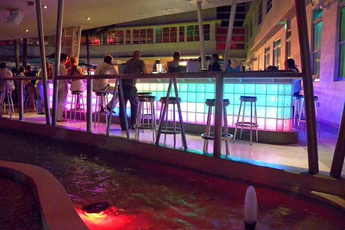 a bar with bar stools and a pool of water