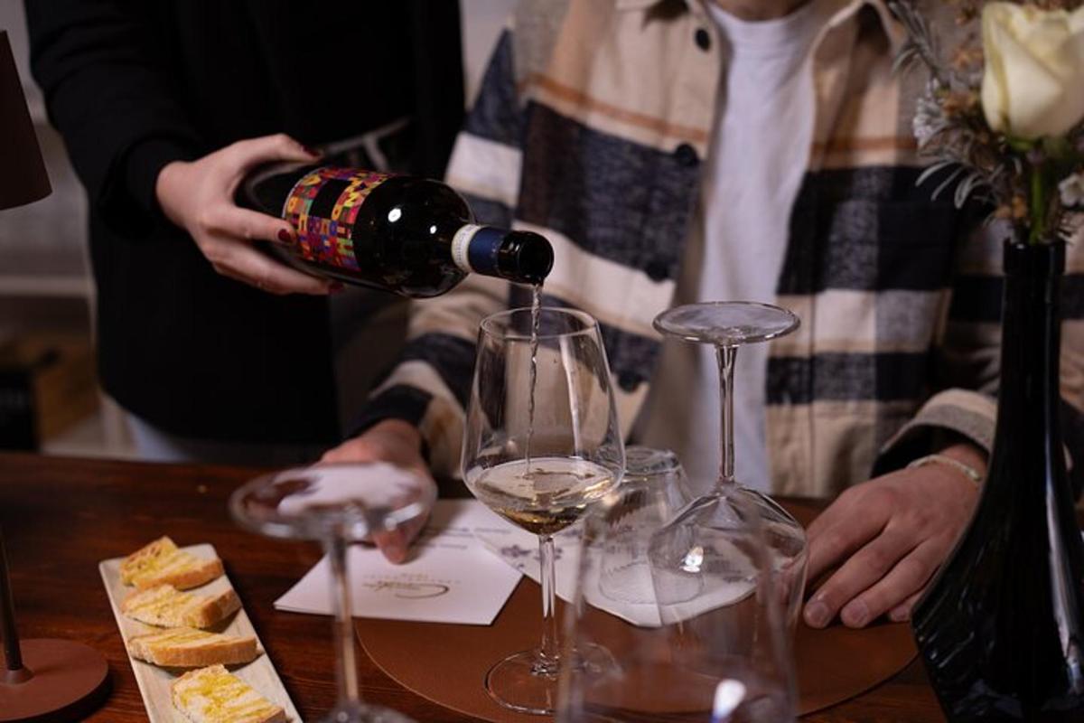 en person, der hælder et glas vin på et bord