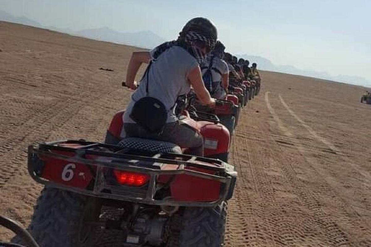 een groep mensen die op motorfietsen door de woestijn rijden