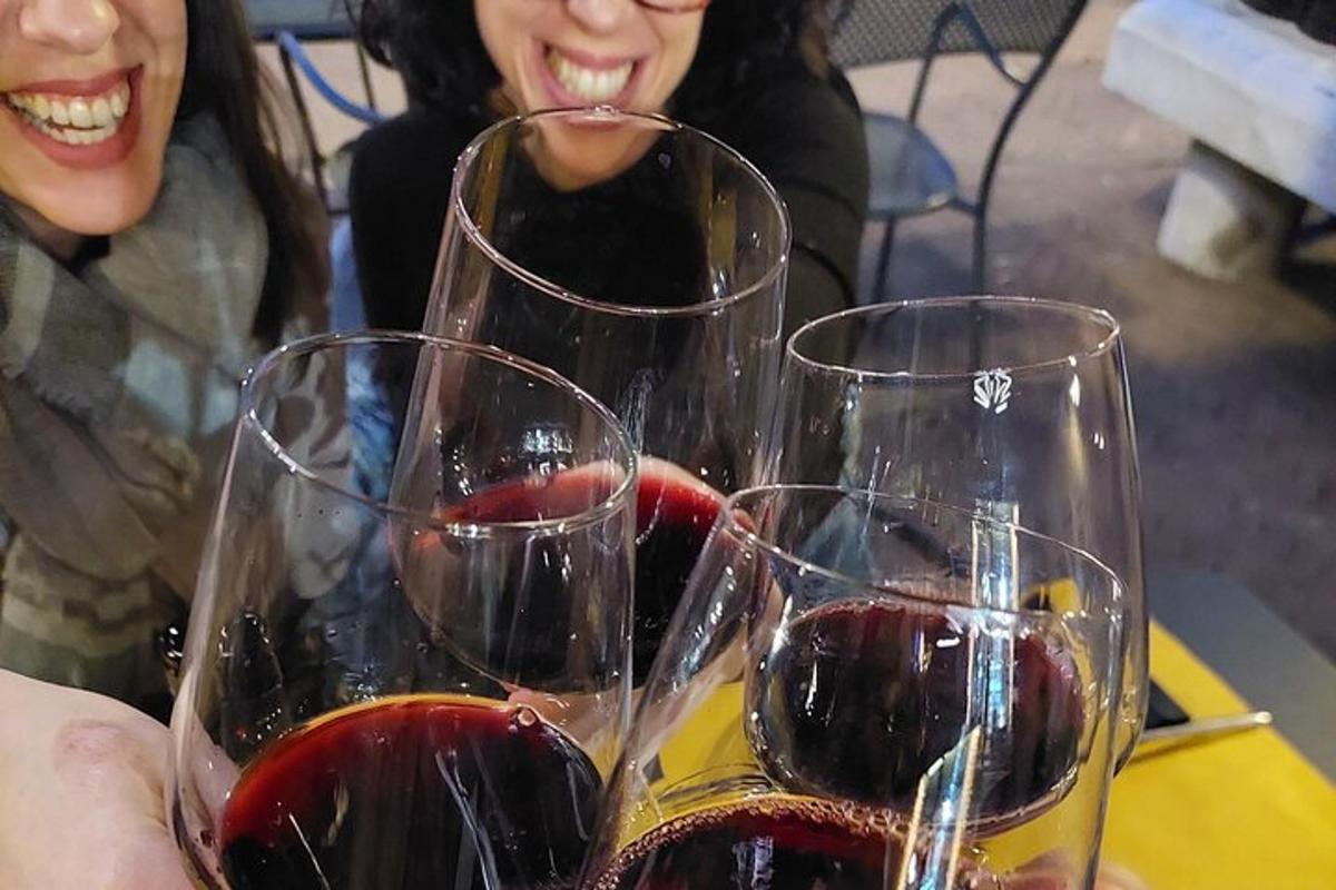 dve ženski, ki sedita za mizo s tremi kozarci vina