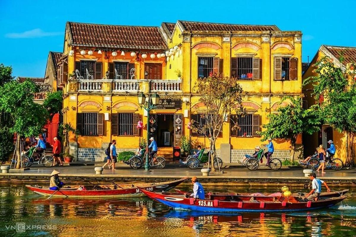 a group of people in boats on the water in front of a building