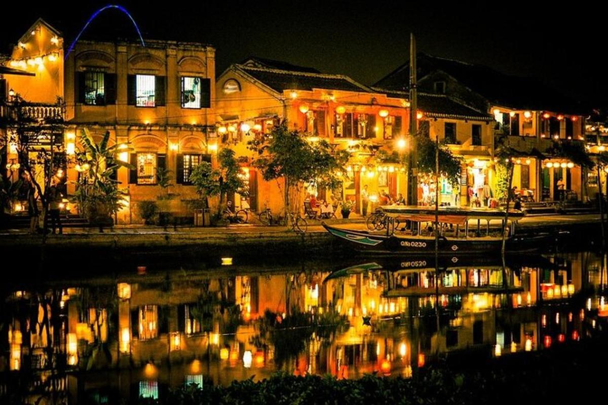 una città illuminata di notte con una barca in acqua
