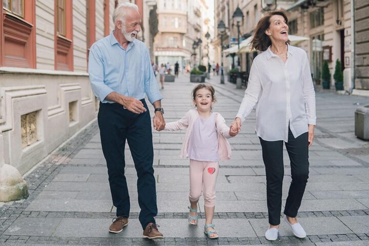 een ouder echtpaar en een klein meisje lopen door een straat