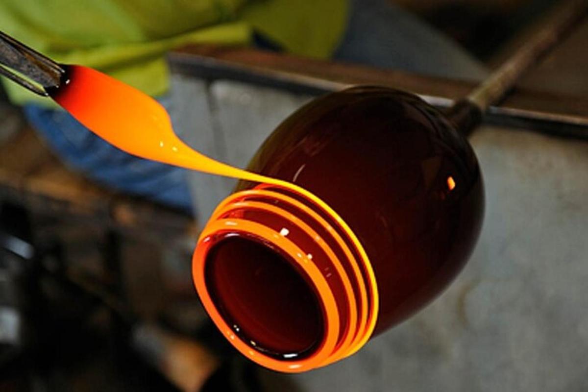 un cucchiaio arancione è appeso a una tazza rossa