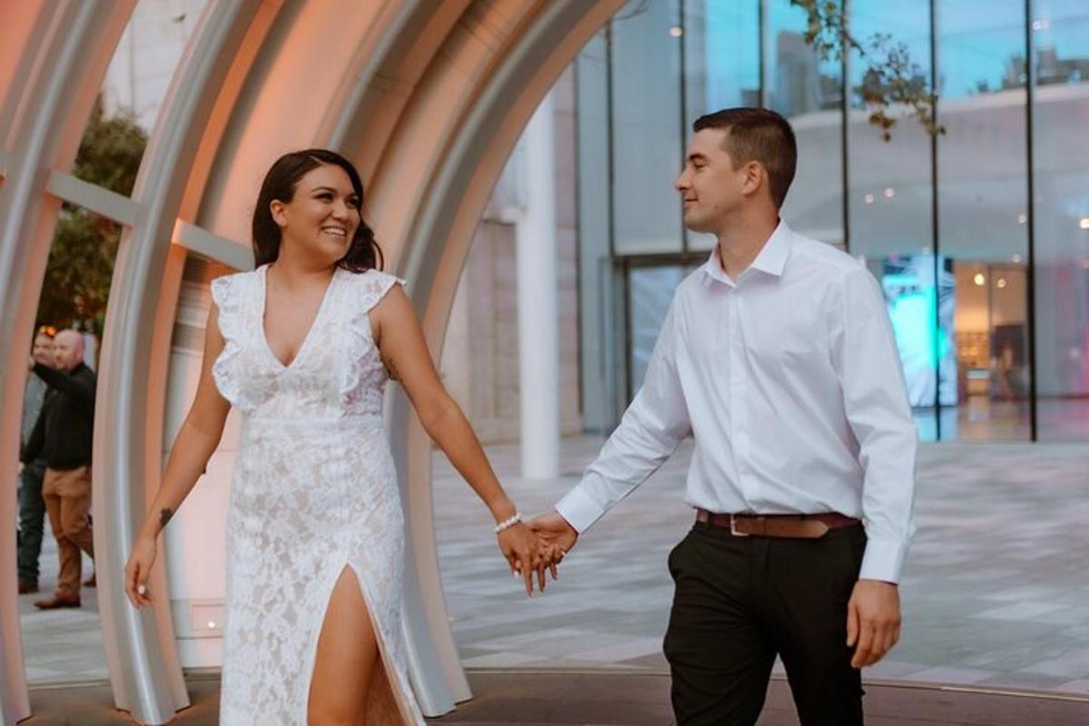 a bride and groom holding hands while walking together