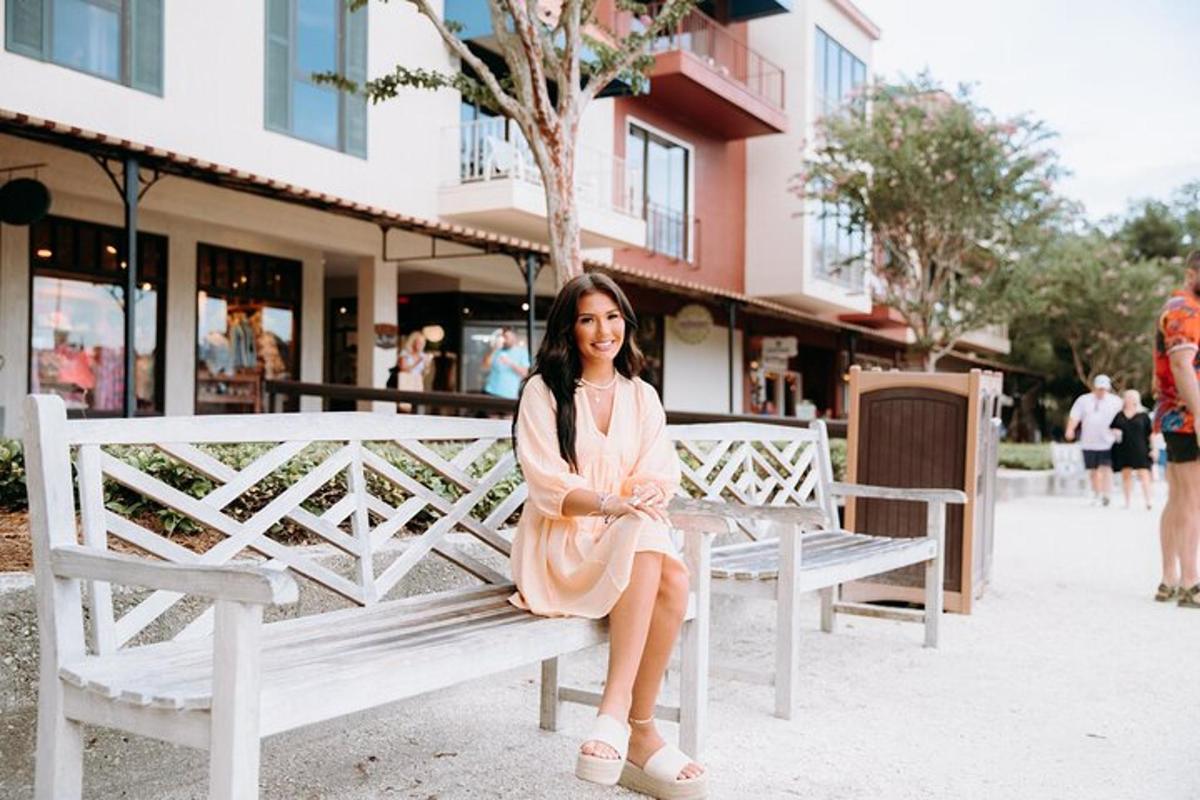 a woman in a pink dress sitting on a bench