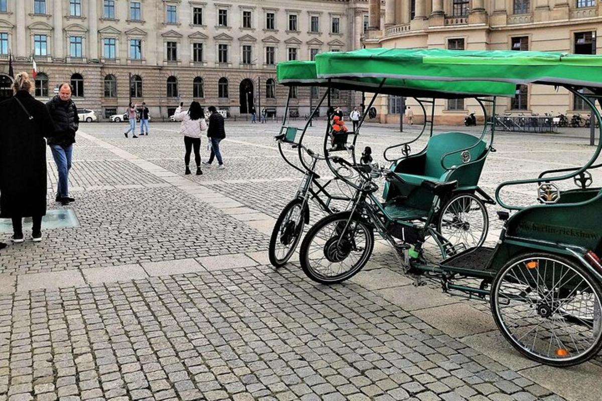 Un carruaje verde con una bicicleta estacionado en una calle