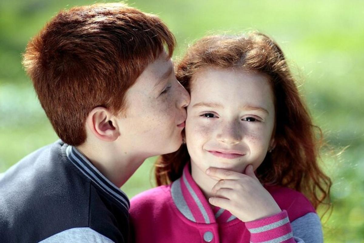 Un niño y una niña se están besando