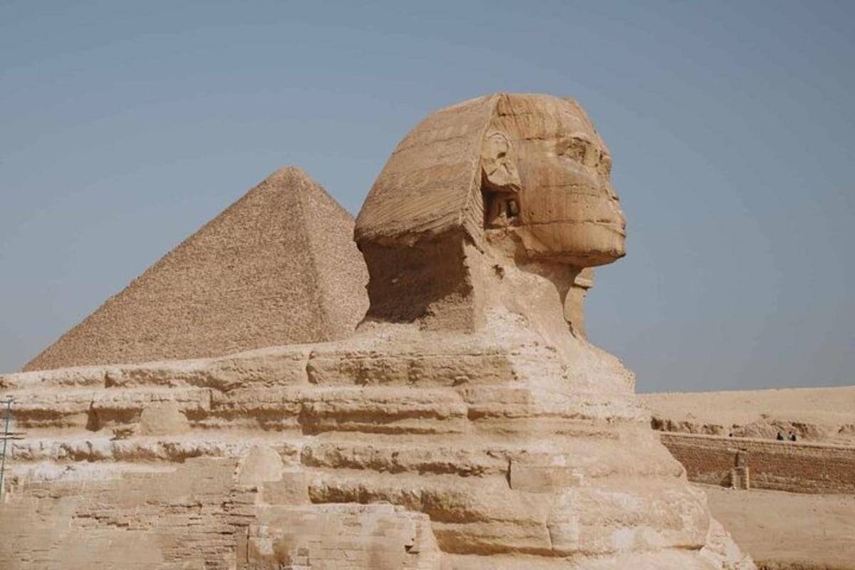 socha před sfingou a pyramidou