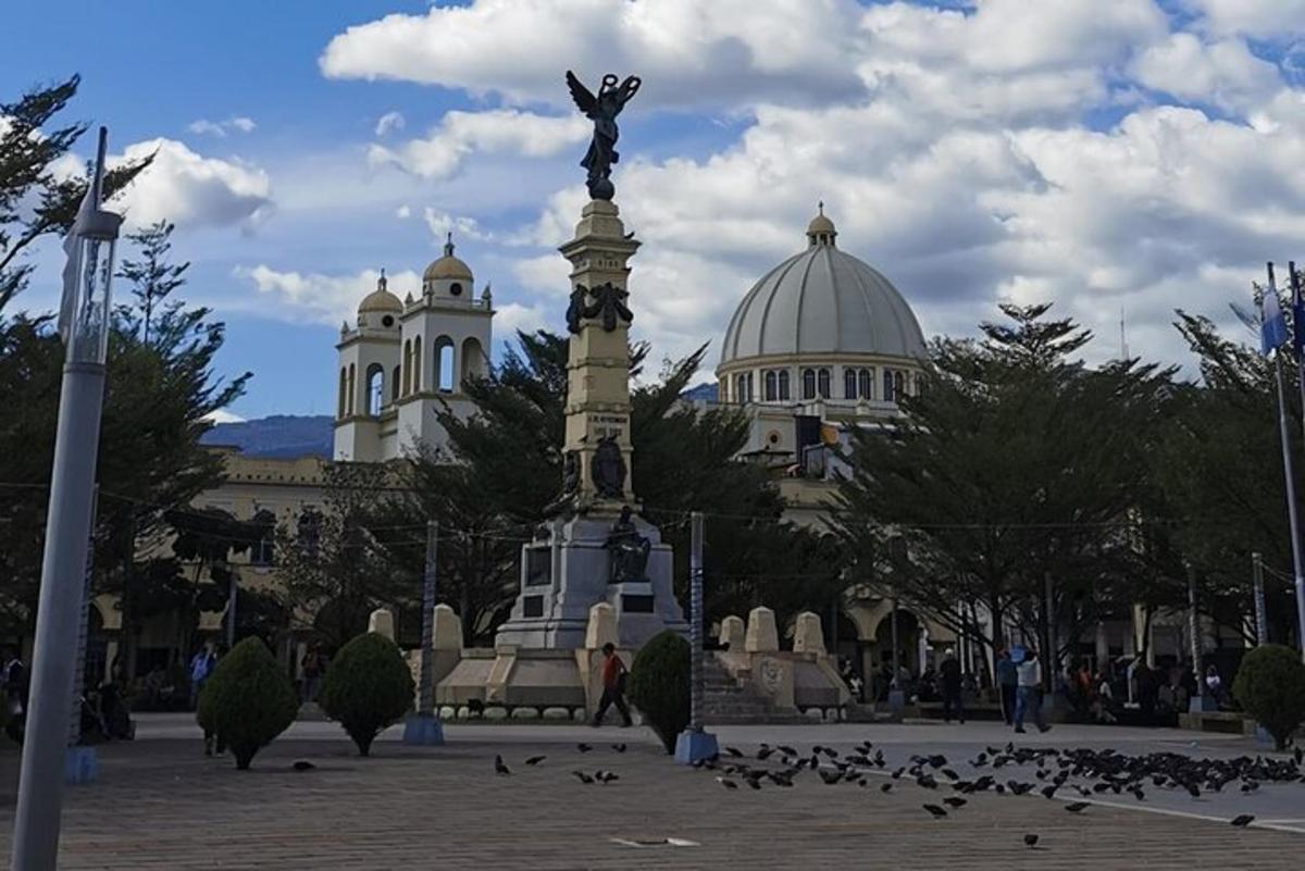 Una estatua frente a un edificio con pájaros a su alrededor.