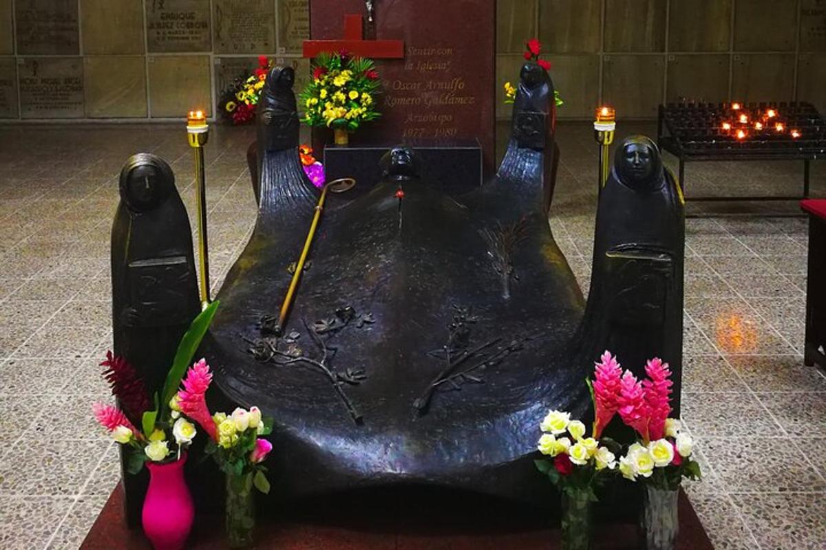 Una estatua de dos personas en un monumento con flores.