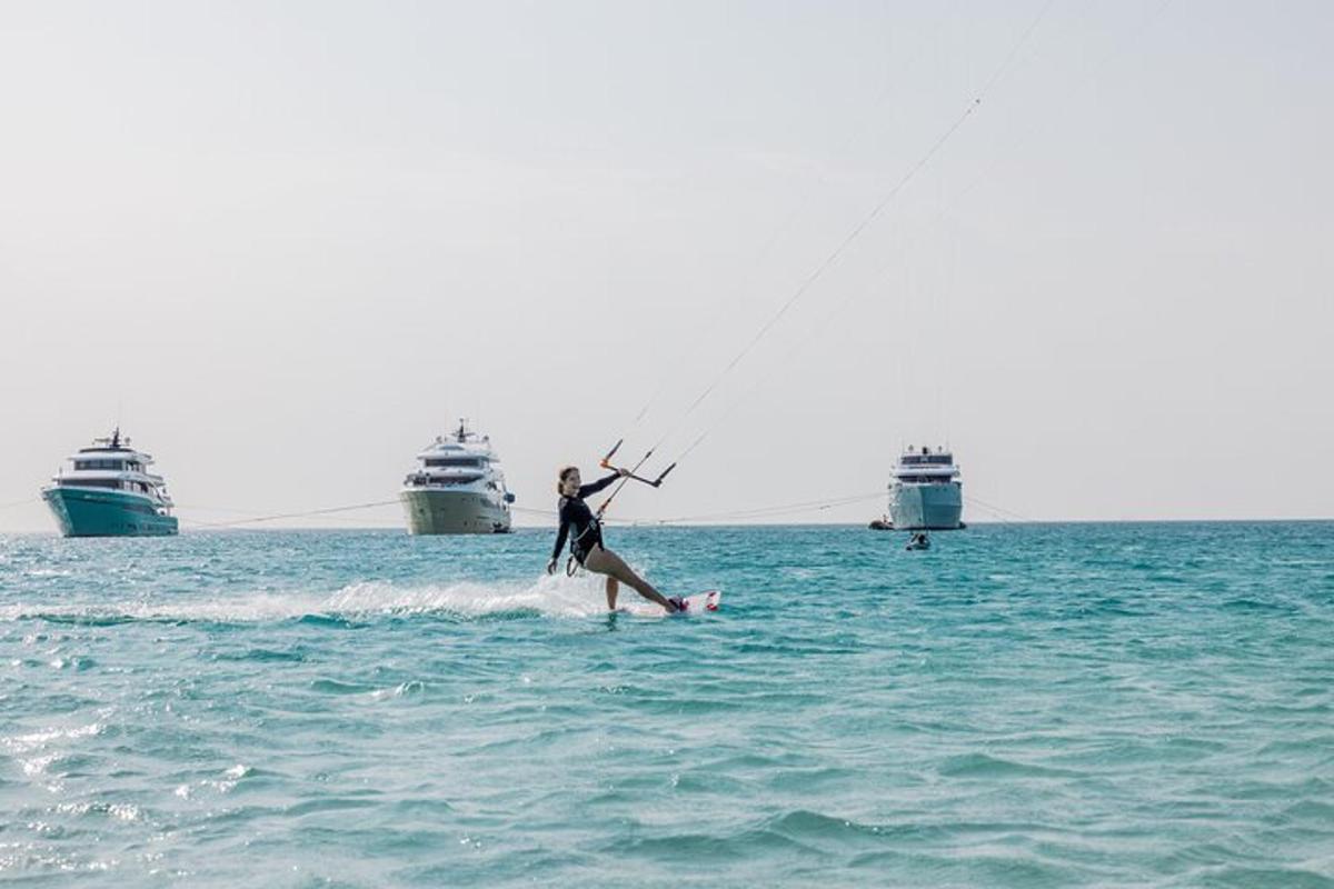 una persona su una tavola da surf in acqua con due navi