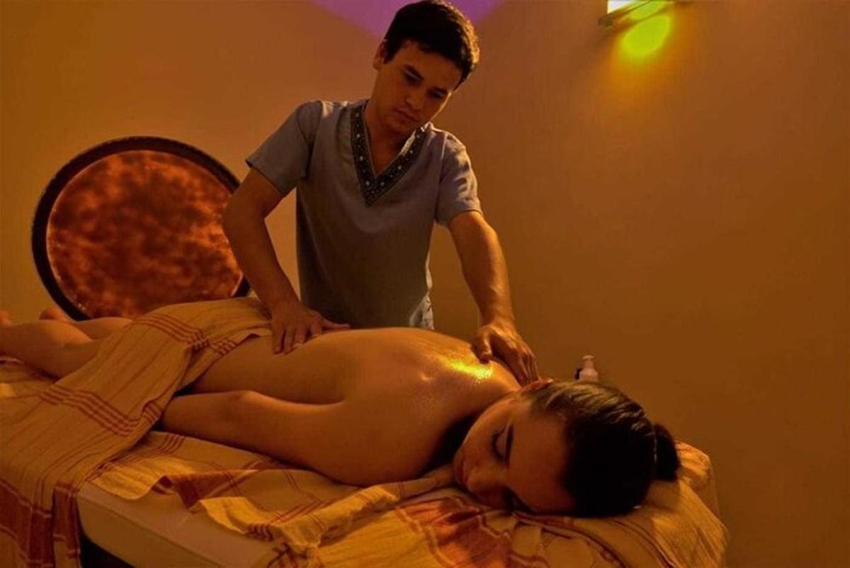 een man geeft een vrouw een massage op een bed