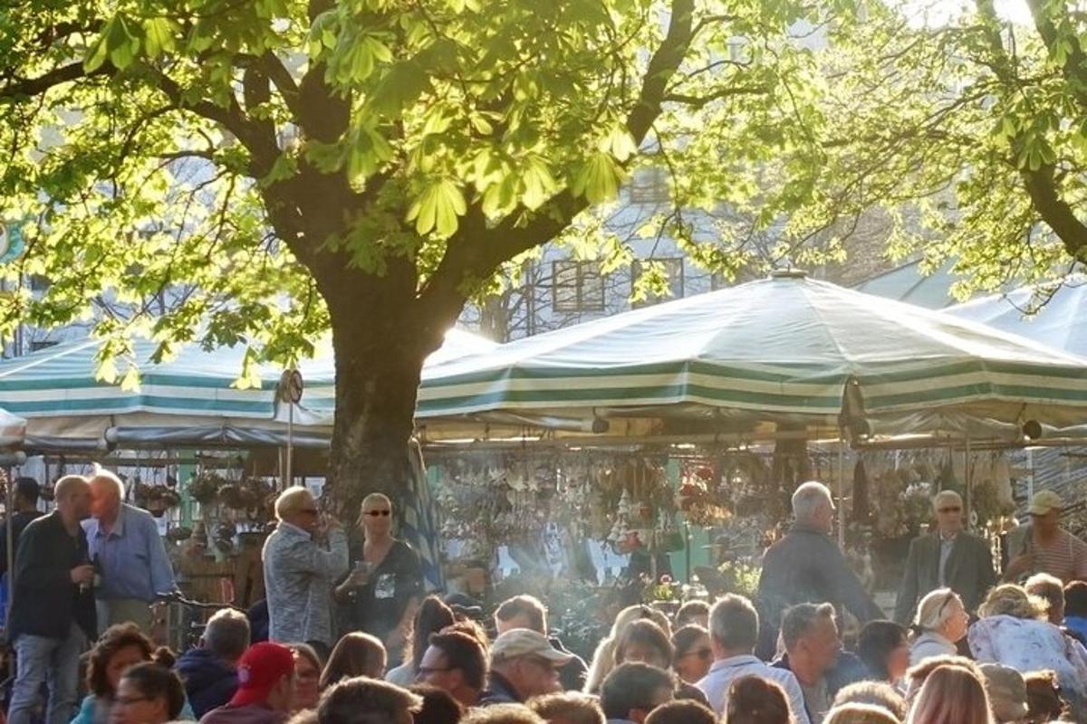 una multitud de gent dreta en un mercat sota un arbre