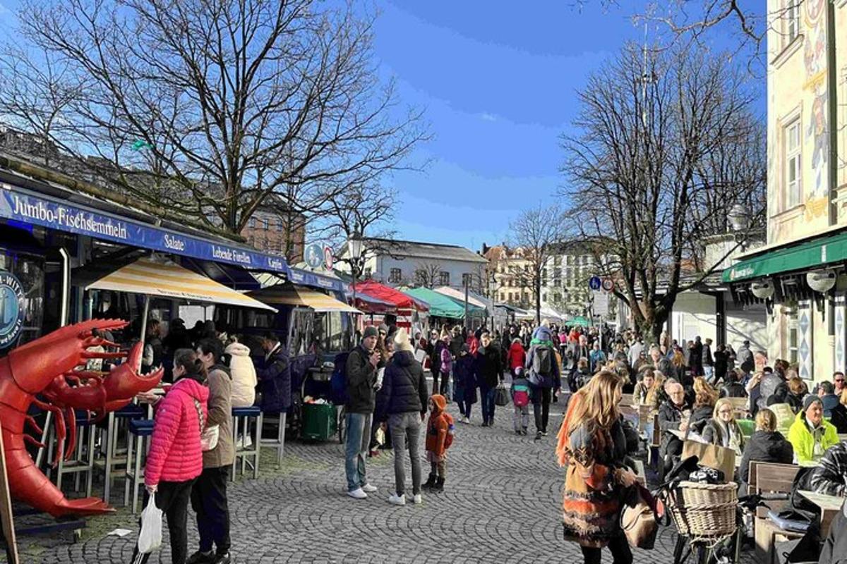una multitud de gent caminant per un carrer amb botigues