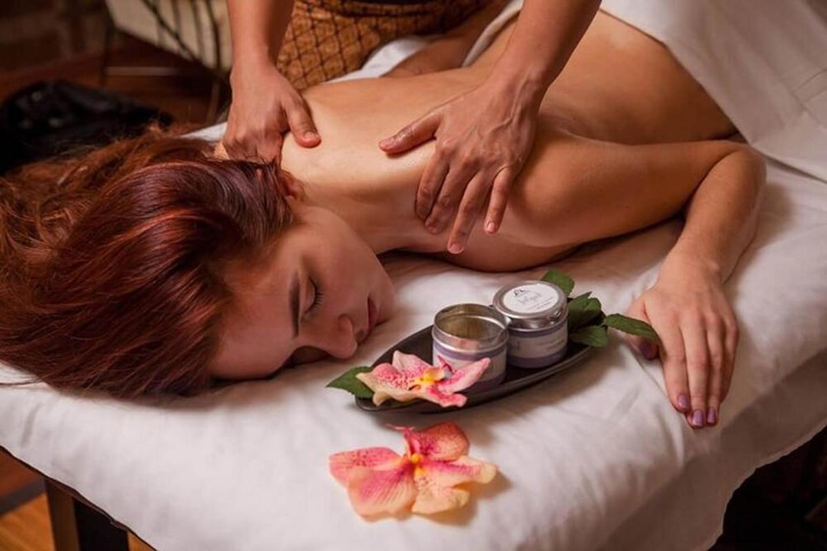uma mulher deitada na cama recebendo uma massagem