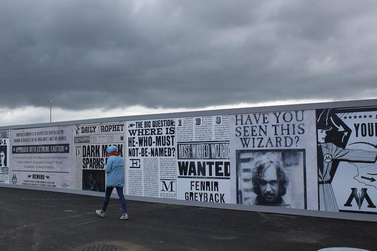 a person walking past a wall with posters on it