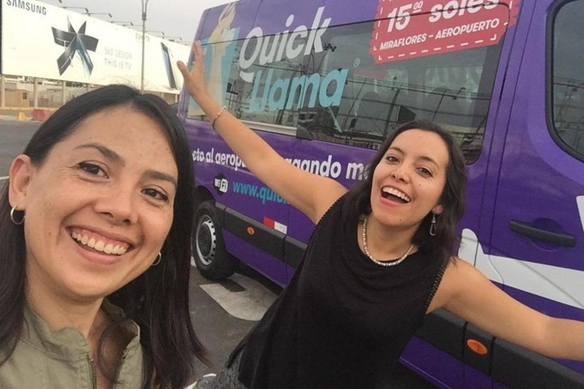 dua orang wanita berdiri di hadapan sebuah bas berwarna ungu