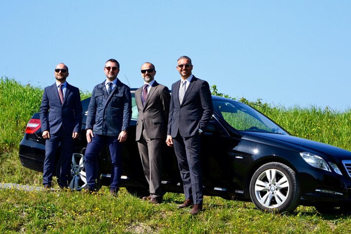 un grup de bărbați în costume care stă lângă o mașină