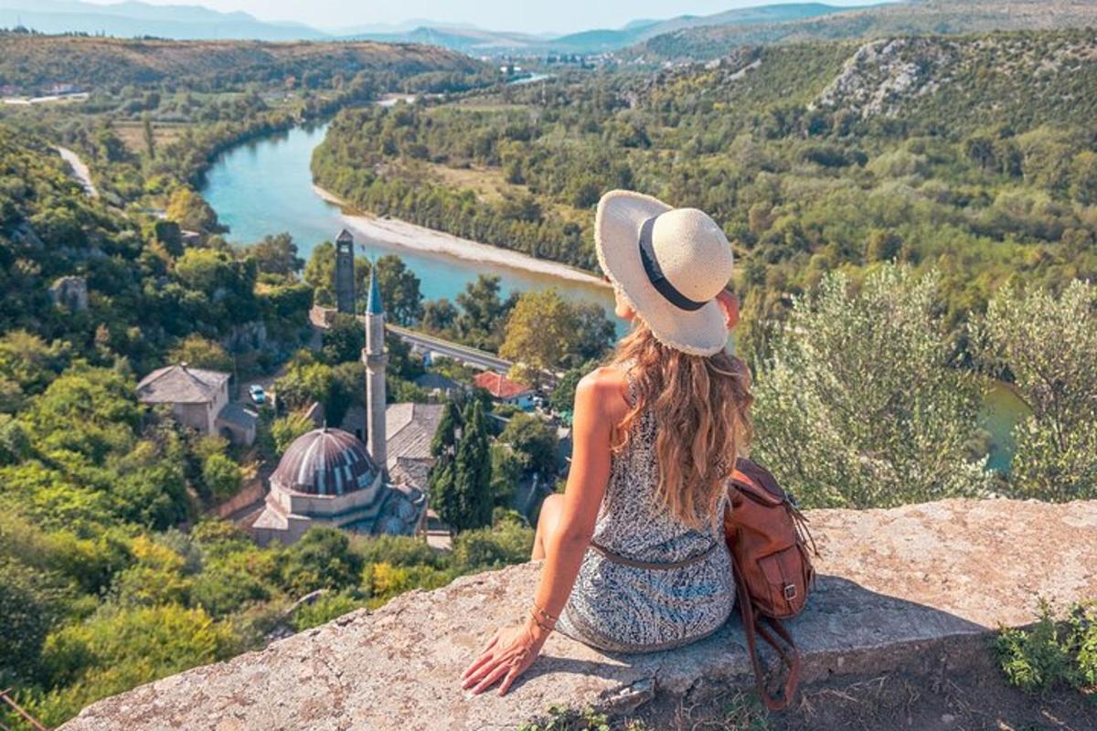 žena sediaca na skale a pozerajúca sa na rieku