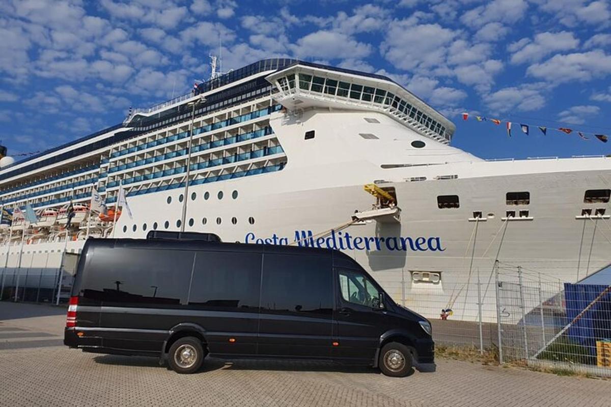 a black van parked in front of a cruise ship