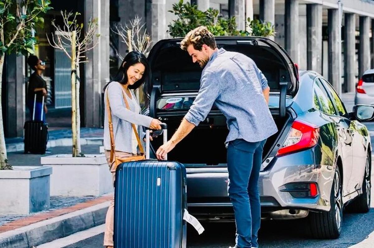um homem e uma mulher com uma mala no banco de trás de um carro