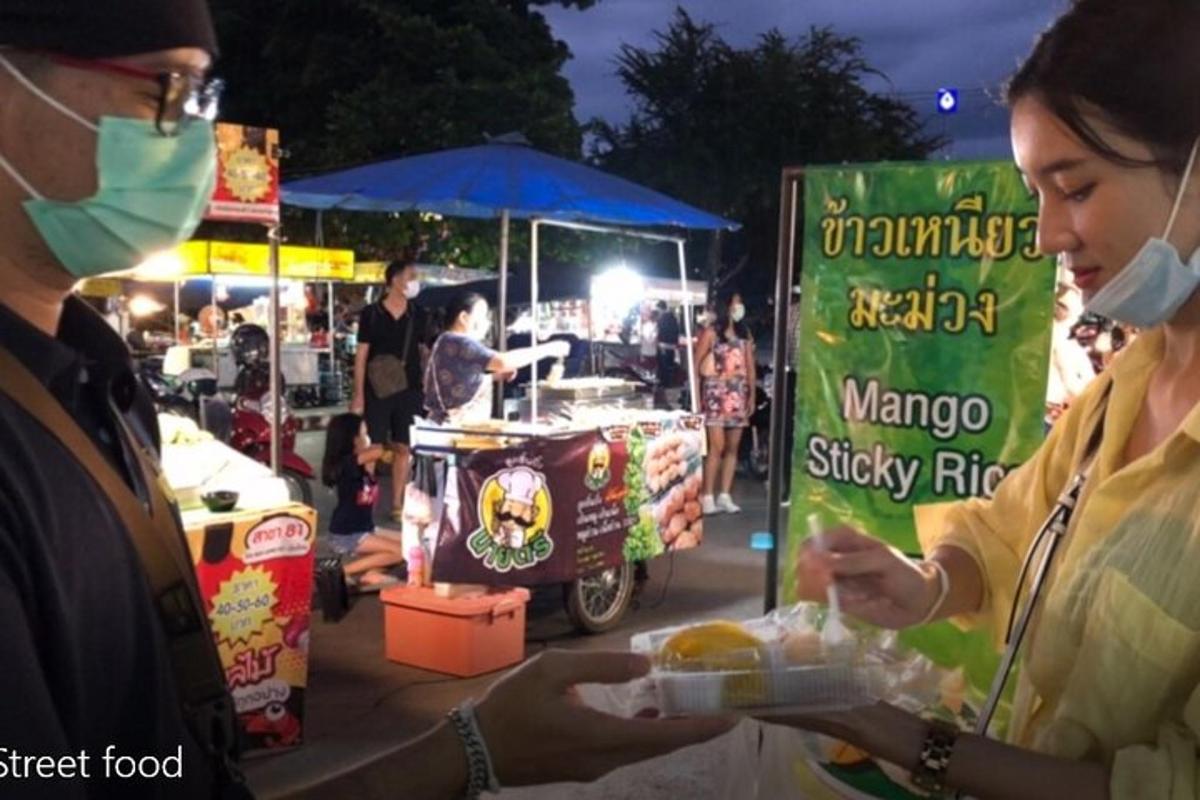 คนสองคนสวมหน้ากากอนามัยกำลังซื้ออาหารที่ตลาด