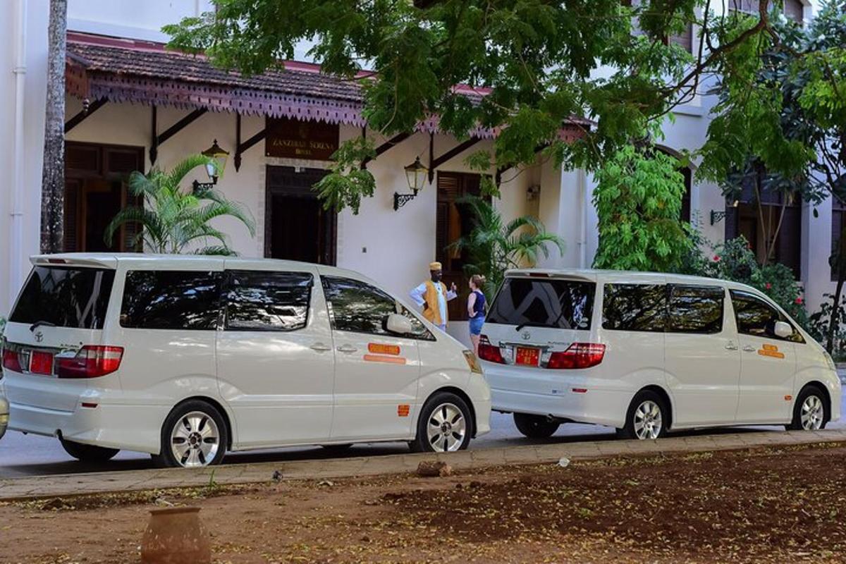 dua buah van putih diletakkan di hadapan sebuah bangunan