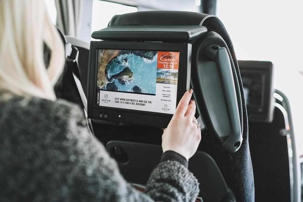žena sedící v autobuse a dívající se na televizi