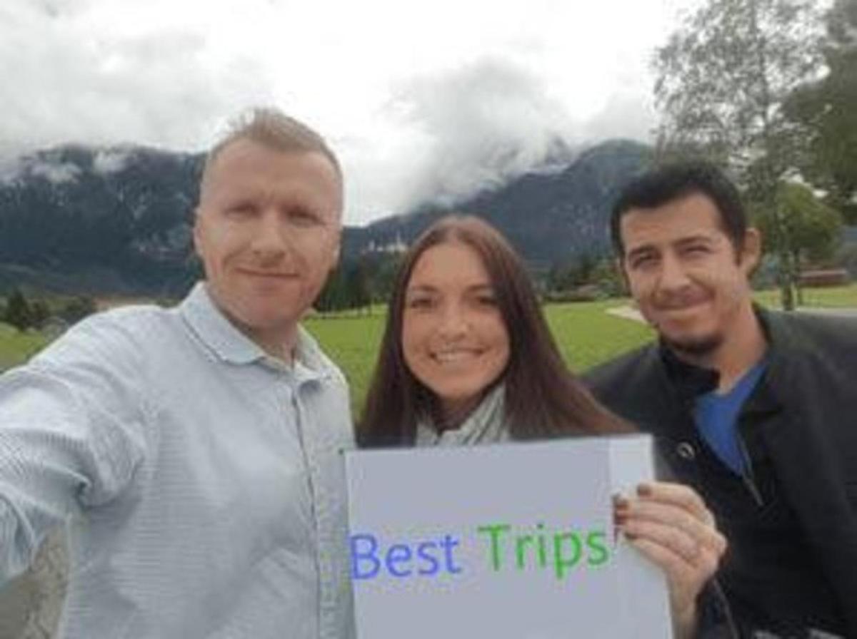 Tveir karlar og kona halda á skilti sem segir „bestu ferðirnar“