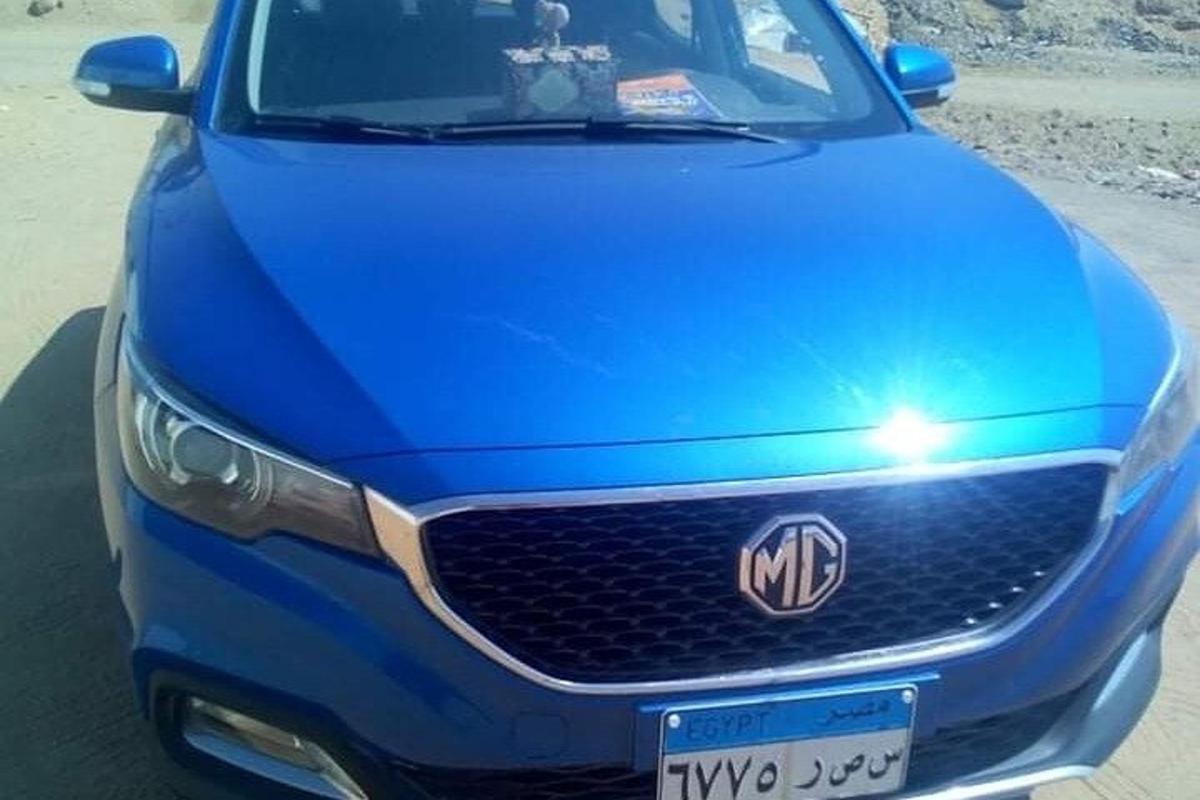 un'auto blu è parcheggiata su una strada