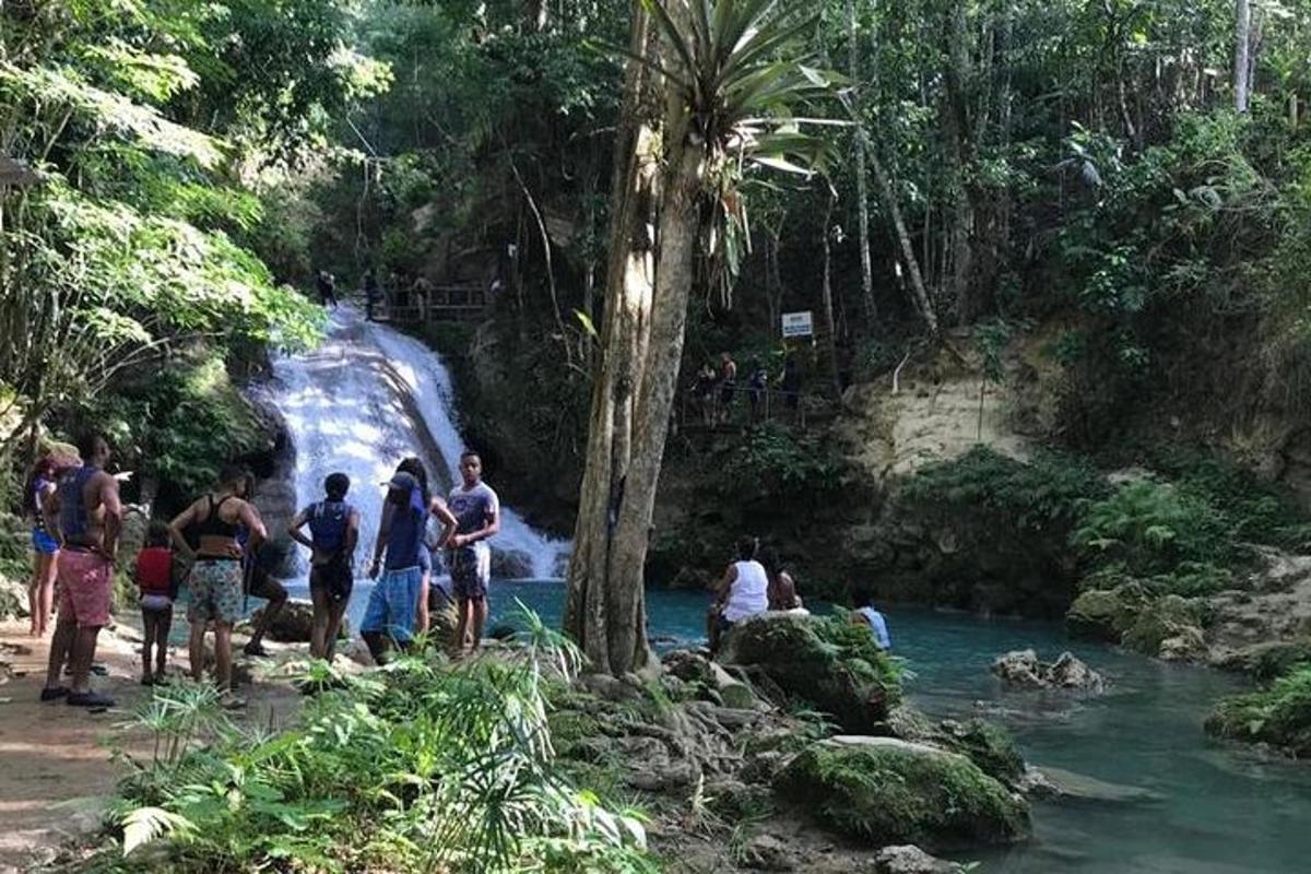 a group of people standing in front of a waterfall