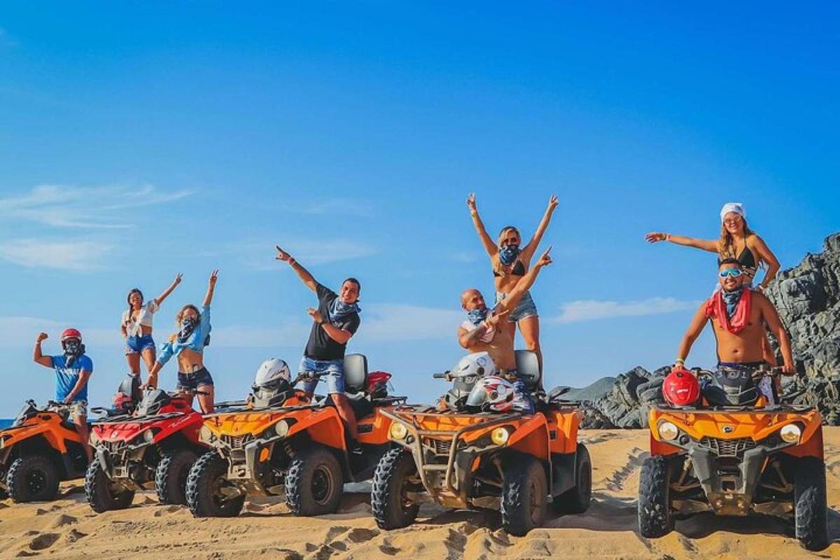 um grupo de pessoas em quadriciclos na areia