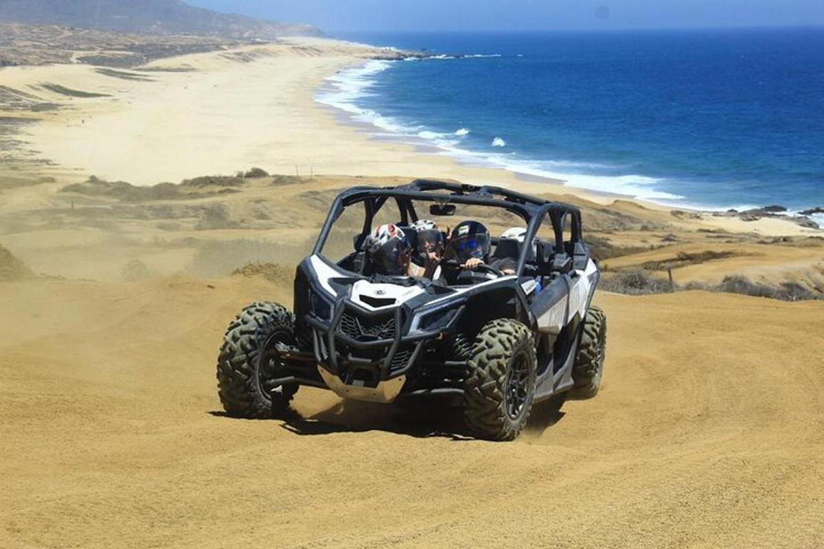 uma pessoa andando de quadriciclo na praia