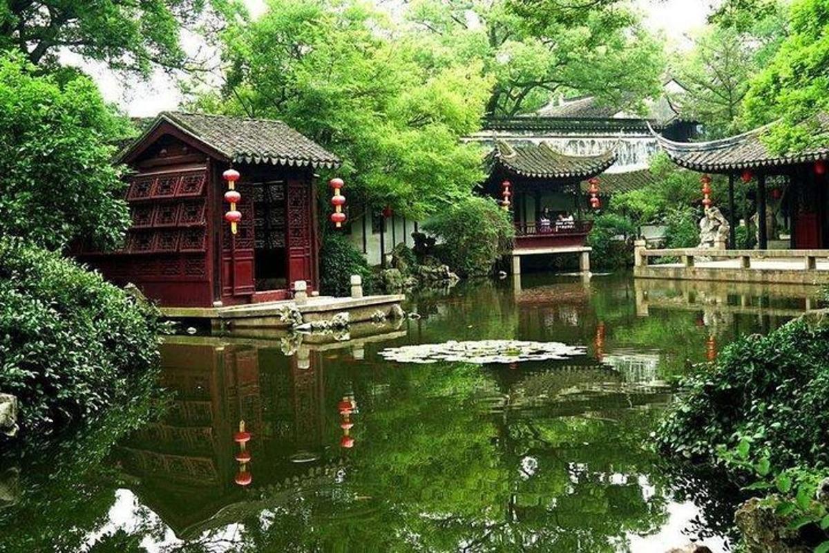 a garden with a pond and a building and trees