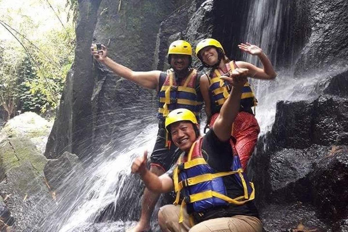 tre persone su una zattera in una cascata