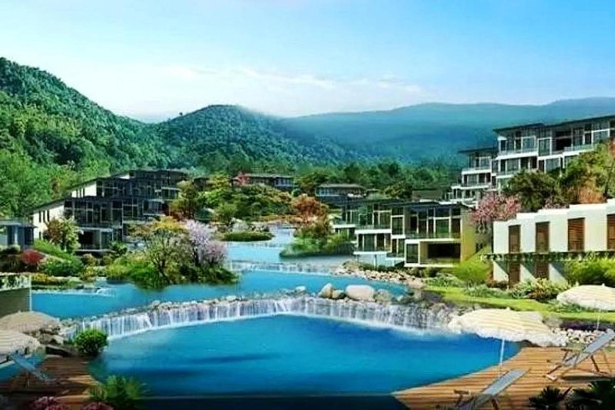 a large swimming pool with a waterfall in a resort