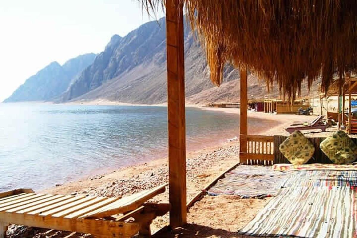 pantai dengan kerusi dan payung dan air