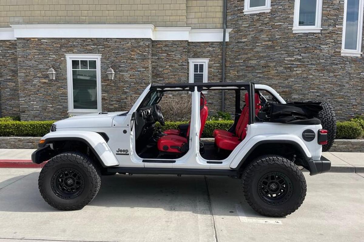 en hvit jeep parkert foran en bygning