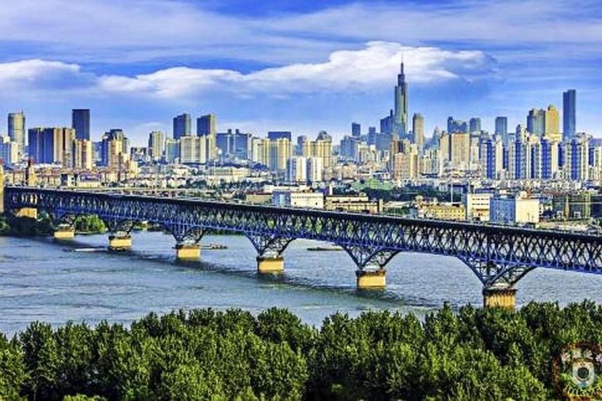 a bridge over a river with a city in the background