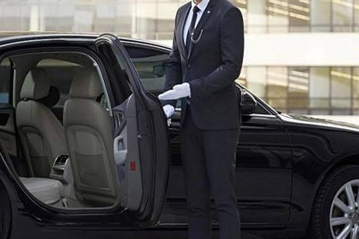 a man in a suit standing next to a car