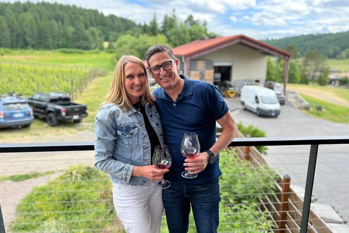 a man and woman standing on a balcony holding wine glasses