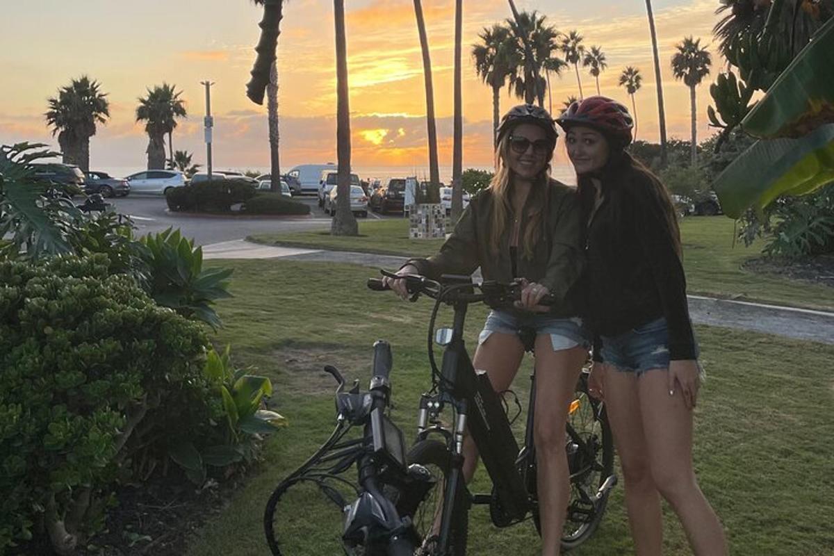 duas mulheres estão paradas ao lado de suas bicicletas